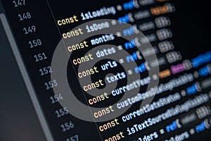 close-up of computer screen with colorful javascript code, focus on const keyword, software development and programming