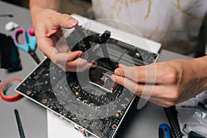 Close-up of computer technician mounting CPU cooler bracket on motherboard, ensuring precise hardware installation