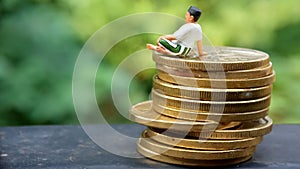 Close Up Conceptual, Midle Aged man enjoy his earn or income, sit at stack of 500 golden coins, with negative space for text area