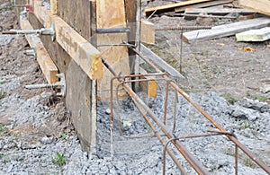 Close up on concrete footer in slabs. Pour concrete footings in wooden slabs with reinforcing bars for new house foundation