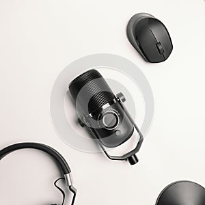 close-up of a condenser microphone in black on a white background and equipped with a mouse and earphones