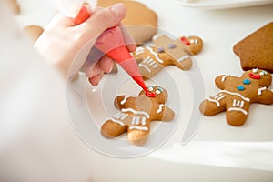 Close up of confectioner hand decorating a gingerman