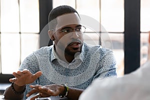 Close up confident African American businessman speaking at corporate meeting