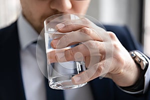 Close up confident businessman drinking fresh pure mineral water