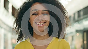 Close up confident curly African American woman looking at camera smiling laughing rejoicing enjoy face girl shopping