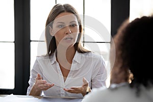 Close up confident serious businesswoman talking with business partner.