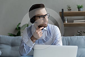 Close up confident thoughtful businessman in headphones looking in distance