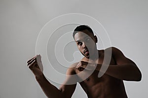 Close-up of confident young black male boxer practicing boxing poses in studio.