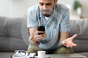 Close up confused man having problem with phone, receive bad news