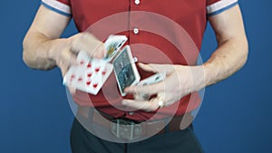 Close up conjurer in red shirt shuffle playing cards, show Queen of Spades