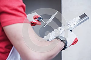 Construction Worker Applying Drywall Compound On Taping Knife photo