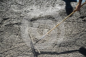 Hand with rake spreading the concrete photo