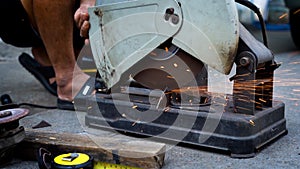 Close up a construction worker cuts off metal fittings with a grinder.