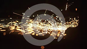 Close up construction worker cutting steel beam. Hot metal sparks