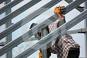 close up construction worker welding new house roof beam