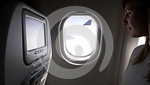 CLOSE UP: Content businesswoman on transatlantic flight looks through her window photo