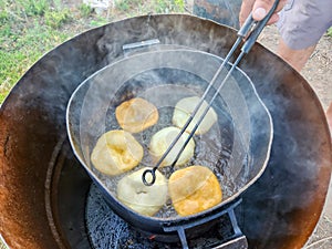 Close up of cook hands flipping Argentinian frybreads to cook on both sides. Sopaipilla. Traditional foods photo