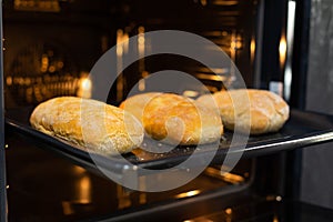 Close-up. The cook prepares bread in an electric oven.