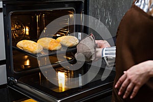 Close-up. The cook prepares bread in an electric oven.