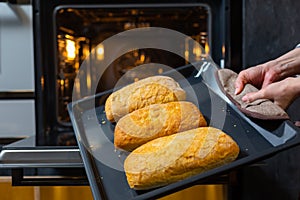 Close-up. The cook prepares bread in an electric oven.