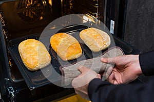 Close-up. The cook prepares bread in an electric oven.