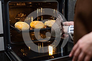 Close-up. The cook prepares bread in an electric oven.