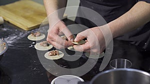 Close-up of cook preparing dumplings with minced meat. Art. Cooking traditional dumplings by professional chef in