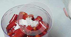 Close-up. The Cook Puts Three Tablespoons Of Coarse Sea Salt In A Blender With Chopped Hot Peppers To Grind Them For Sauce.