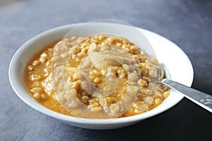 close up of cooked dhal or haleem in a bowl on table