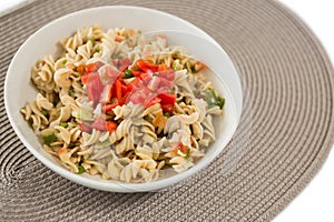 Close up of cooked rotini served in bowl on place mat