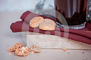 Close up of cookies, glass cup of cooffe on red napkin, marble pad. Copy Space