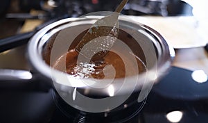 Close-up cooking caramel sauce in pan at home
