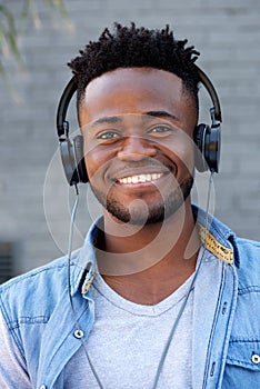 Close up cool young black guy listening to music with headphones