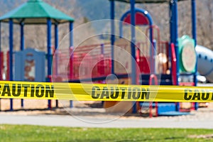 Close-up of cordon tape blocking off a children`s playground during coronavirus pandemic