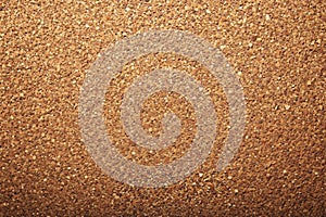 A close up of a cork board with a brown background
