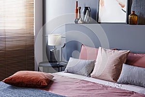 Close-up of a corner of a dark bedroom interior with lamp on a m