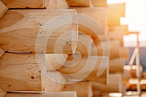 Close-up corner of wooden russian blockhouse, docking of round logs with sun light