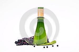 The close up cosmetic bottle of green glass with black bird cherry bunch and leaves. Empty white background, copy space