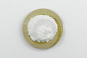 Close-up of a cosmetic dry white clay powder ion wooden round plate