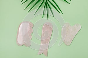 Close Up Cosmetic Massage Pink Jade Gua Sha Scrapers for Facial and Body Skin Care Spa and Beauty Concept Green Background Flat