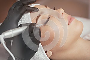 Close up cosmetologist making eyeliner permanent makeup