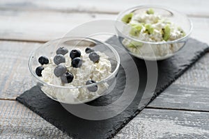 Close - up of cottage cheese with different fillers on a black stone