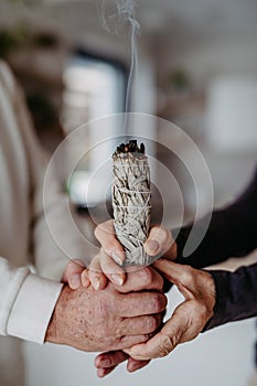 Close up of couple doing ritual with a sage.
