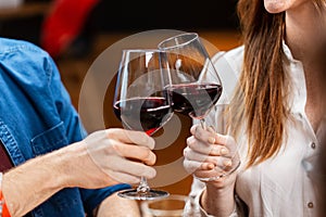 close up of couple drinking red wine at restaurant