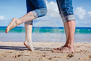 Close up of couple feet kissing on the beach