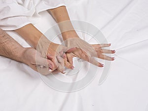 Close up of couple hands lie on bed in bedroom, lovers have intense sex or making love feeling orgasm and satisfaction