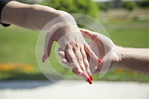Close up on a couple holding hands in the park