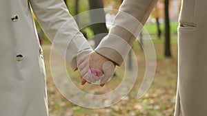 Close up couple holding hands together walking in park outdoors mature unrecognizable partners male female grandparents