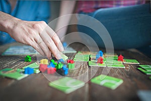 Close up of a couple in love sitting on the floor next to a table, playing ludo board game