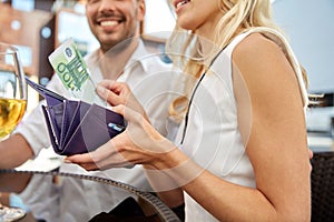 close up of couple with money paying at restaurant